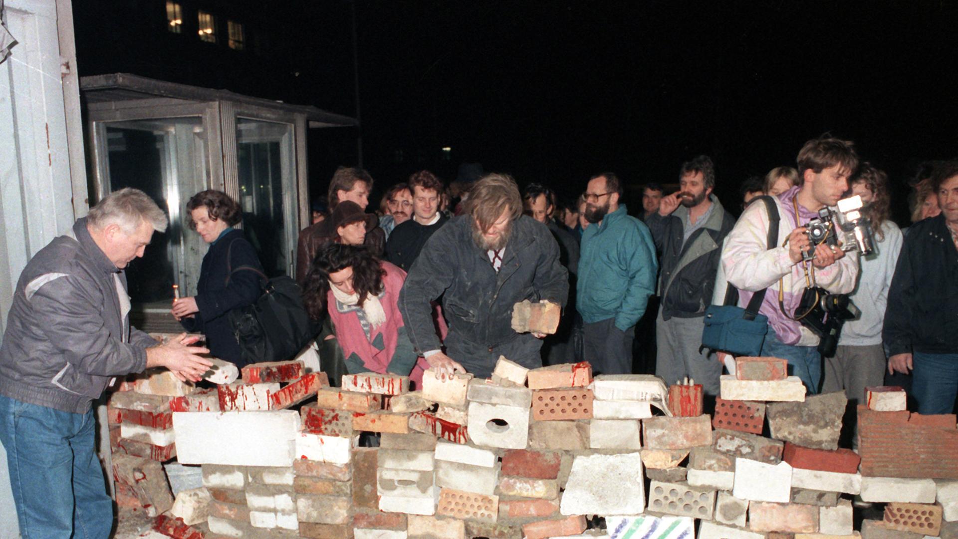 Nach der erzwungenen Öffnung einer Zufahrt zur Stasi-Zentrale (Ministerium für Staatssicherheit der DDR, MfS) in der Ruschestraße in Ostberlin am 15.01.1990 sind Demonstranten damit beschäftigt, symbolisch den Eingang mit Ziegelsteinen zuzumauern. Aus einer Protestdemonstration heraus hatte sich an diesem Tag eine Besetzung des Hauptgebäudes entwickelt, einzelne Räume des einst scharf bewachten Gebäudekomplexes von Stasi-Chef Mielke wurden später verwüstet. In den Wochen danach nahm hier ein Bürgerkomitee zur Auflösung des MfS seine Arbeit auf.