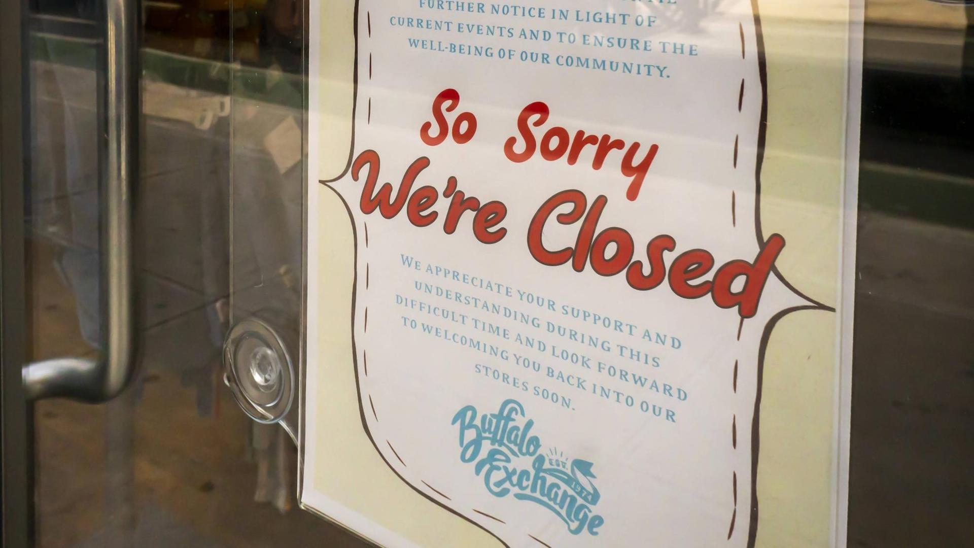 Ein Schild mit der Aufschrift "So sorry we're closed" hängt an der Tür einer Filiale der Second-Hand-Modekette "Buffalo Exchange" in New York.