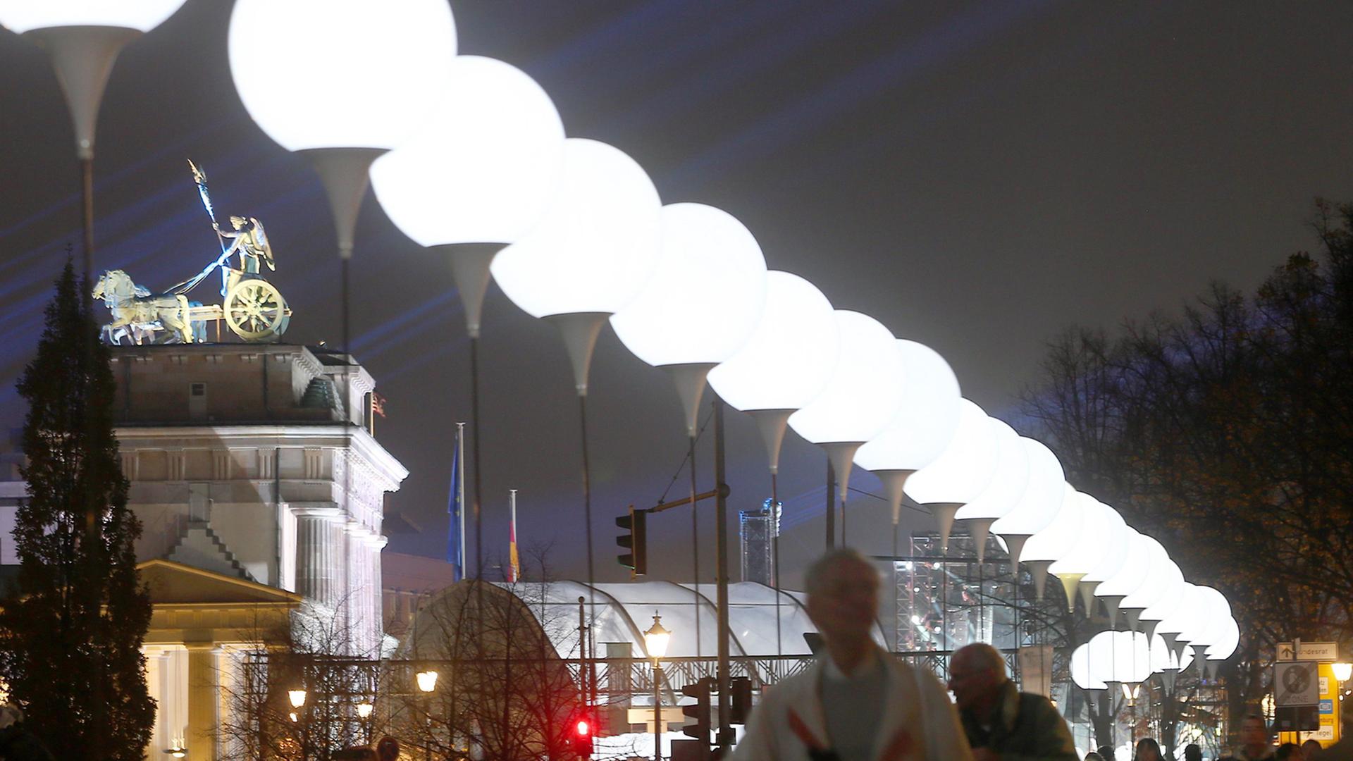Zahlreiche Ballonstelen leuchten am 07.11.2014 entlang des ehemaligen Verlaufs der Berliner Mauer neben dem Brandenburger Tor in Berlin.