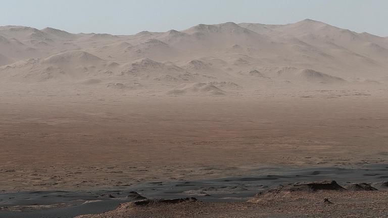 Dieser Blick des Mars Science Labors Curiosity über den Gale-Krater lässt die rötliche Farbe des Marsbodens erkennen, die durch eisenoxidhaltigen Staub hervorgerufen wird