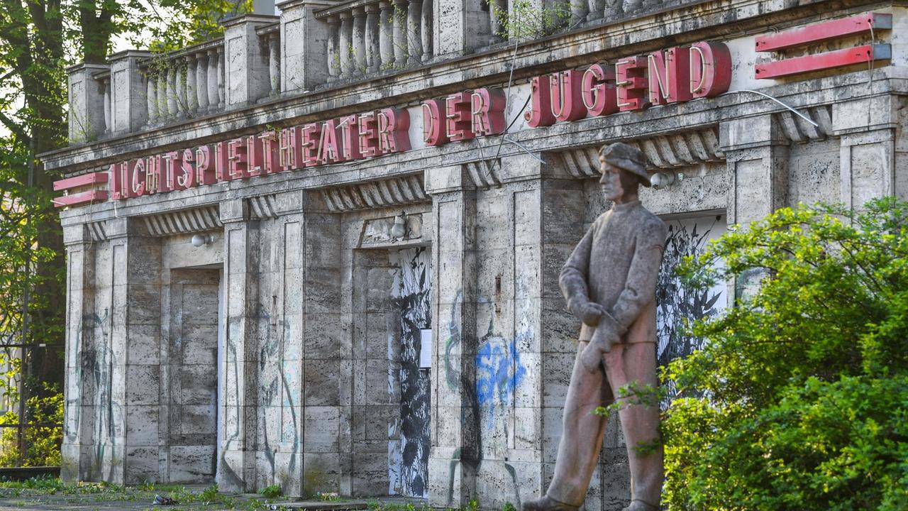 Die Skulptur eines Hüttenwerkers steht vor der verfallenen Front des Kinos «Lichtspieltheater der Jugend»