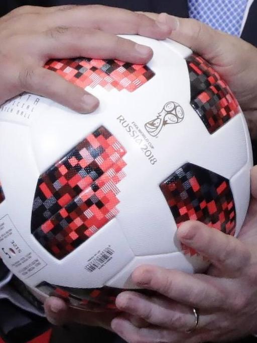 Mehrere Hände auf einem Ball, wie er bei der WM 2018 in Russland zum Einsatz kam.