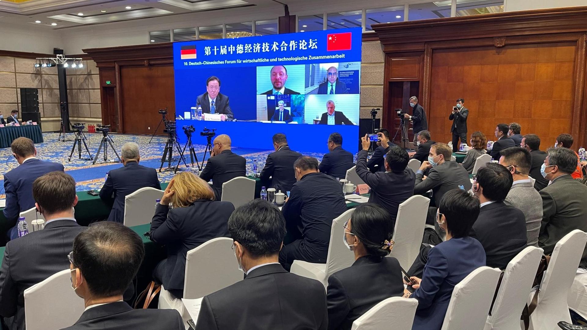 Aus Anlass der deutsch-chinesischen Regierungskonsultationen kamen in Peking rund 100 Unternehmensvertreter zusammen, um über die Wirtschaftsbeziehungen zu diskutieren. Auch aus Deutschland waren Teilnehmer zugeschaltet.