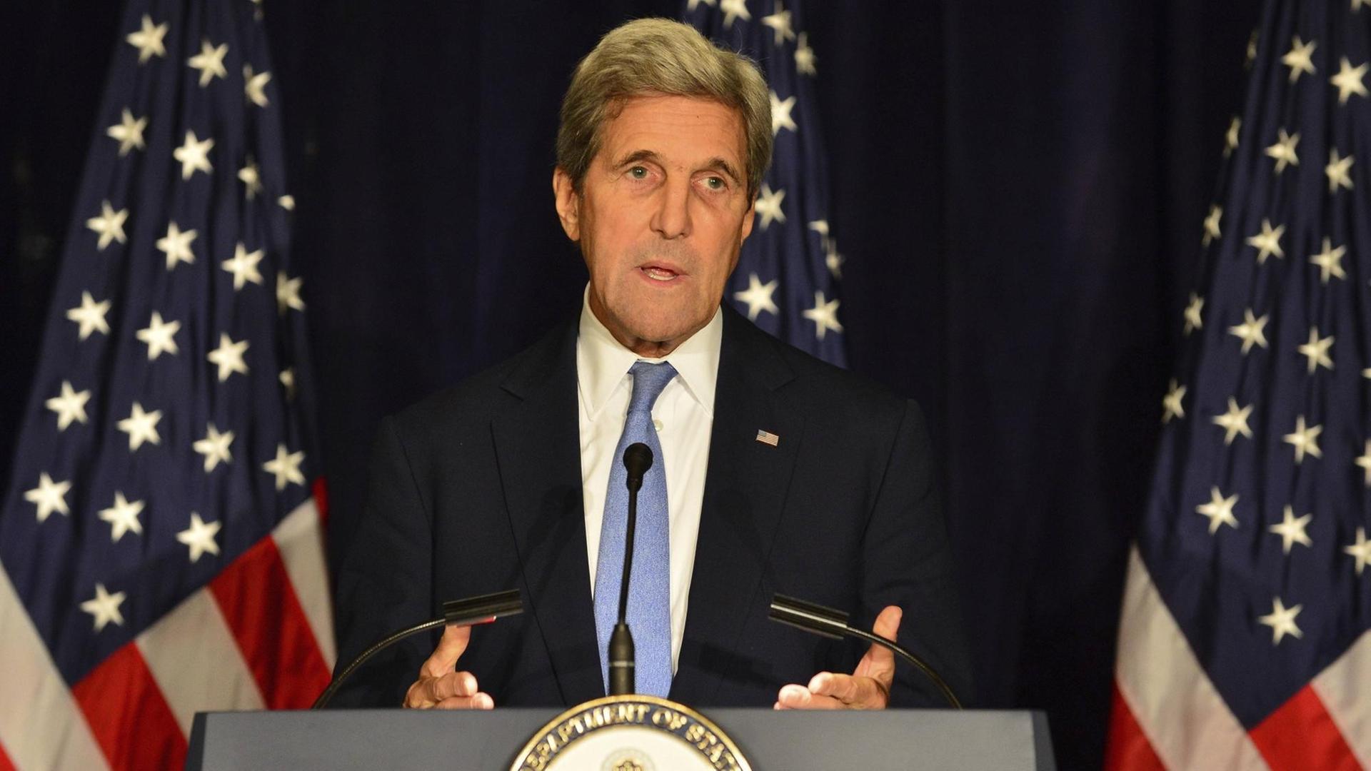Ein Mann spricht vor der amerikanischen Flagge in ein Mikrofon. US-Außeminister John Kerry am 22.9.2016.