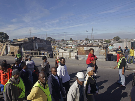 Menschen vor dem Township Khayelitsha an den Rändern von Kapstadt