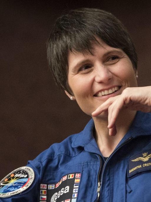 Porträt der italienischen Astronautin Samantha Cristoforetti in ihrem blauen Arbeitsoverall.