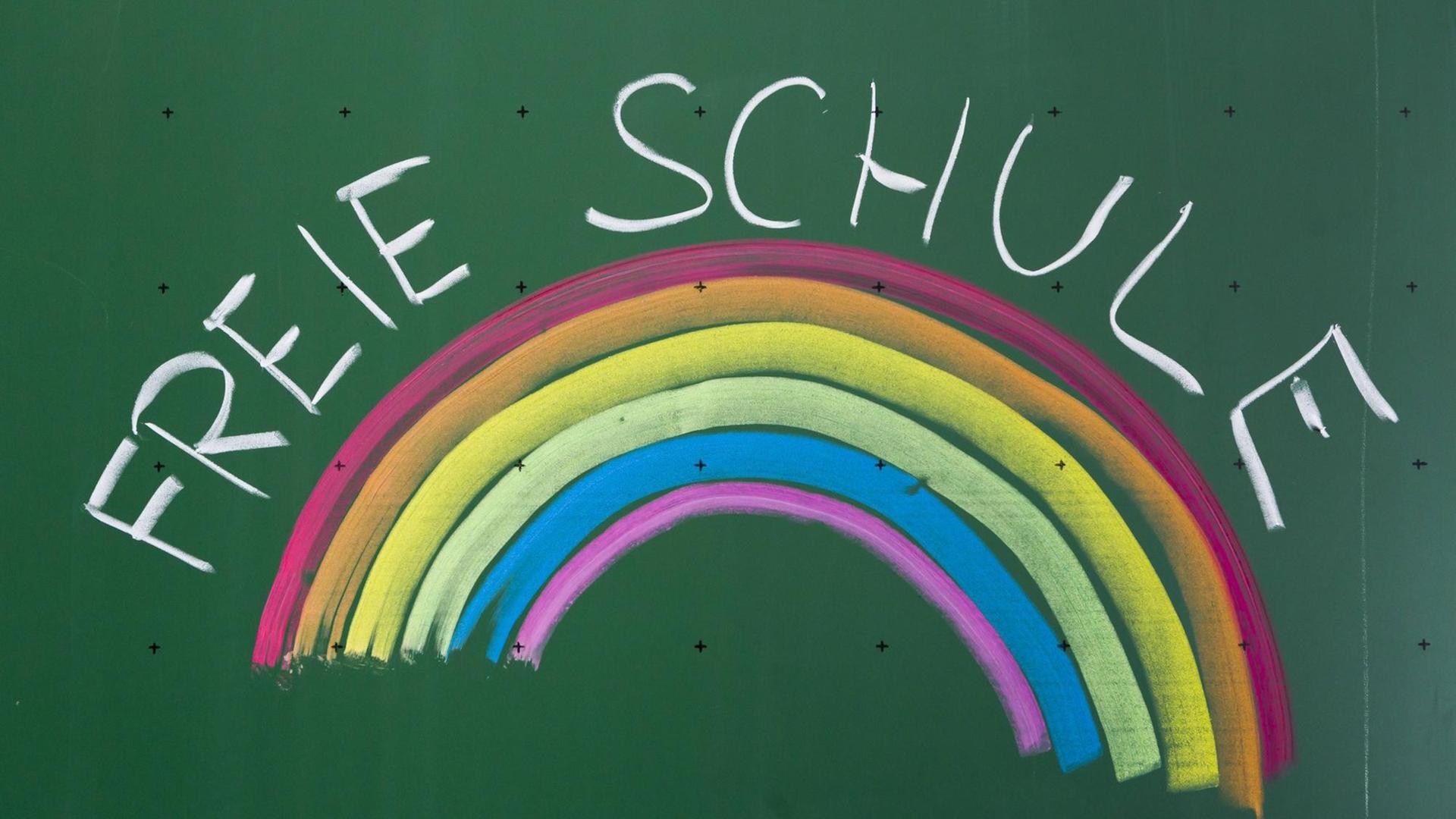 Eine Tafel mit der Aufschrift "Freie Schule" und einem Regenbogen