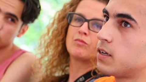 Der 20-jährige Saman aus der nordsyrischen Grenzstadt Kamischli spricht am 27.07.2016 in Berlin bei der Flüchtlingshilfe "Moabit hilft" neben der Betreuerin Christiane Beckmann und dem Flüchtling Ahmet (r).