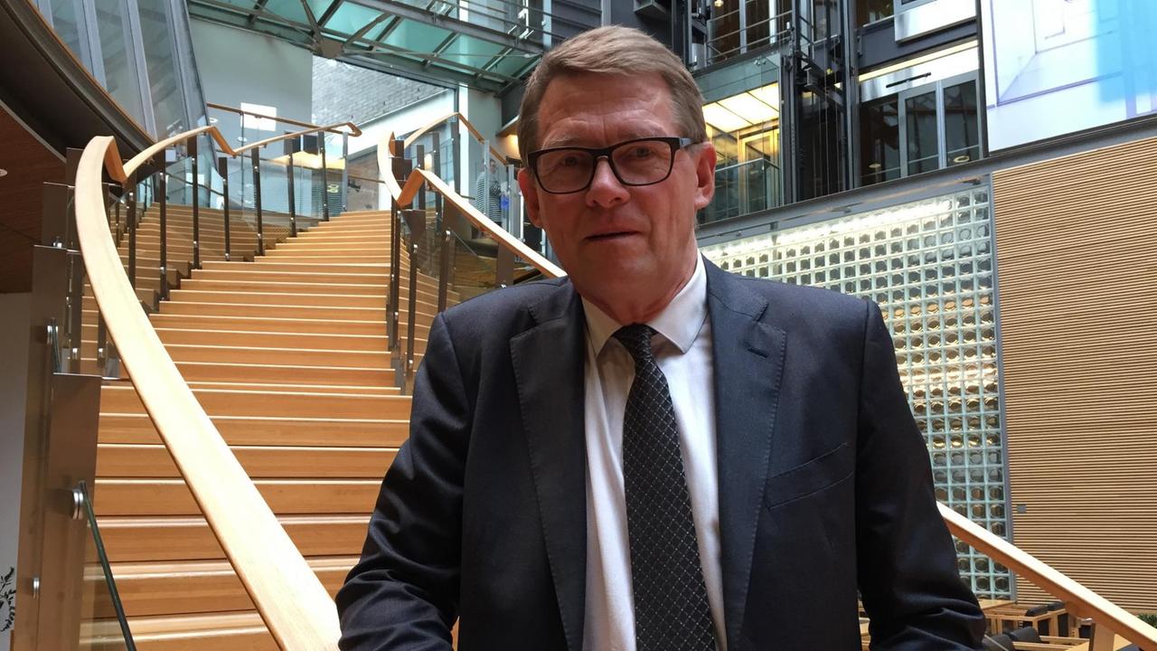 Matti Vanhanen steht an einer Treppe im Parlament in Helsinki