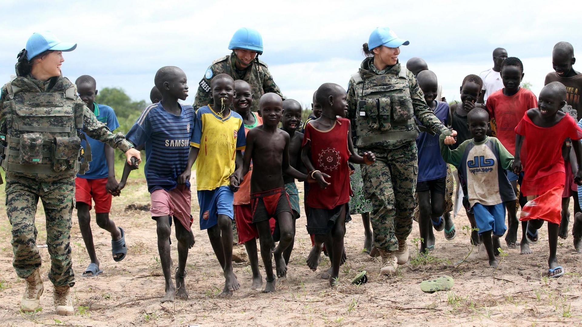 Südkoreanische Blauhelm-Soldaten spielen in der südsudanesischen Stadt Bor mit Kindern.