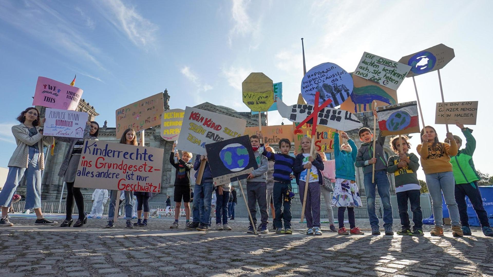 Kinder halten anlässlich des Weltkindertags vor dem Reichstag Transparente mit ihren Forderungen (unter anderem: "Kinderrechte ins Grundgesetz - alles andere ist nur Geschwätz") in die Höhe.