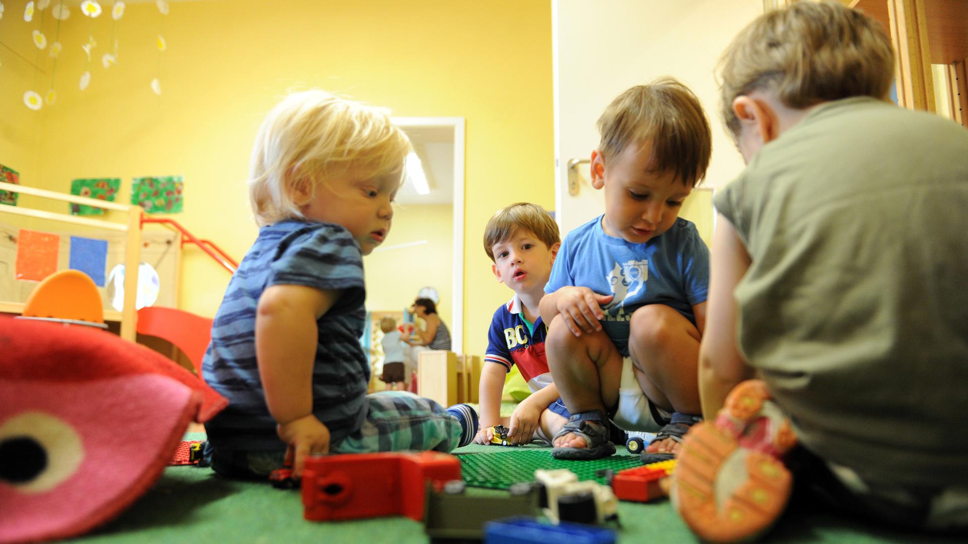 Kleine Kinder spielen in einer Kita.