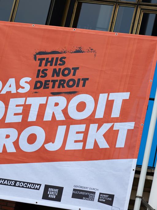 Ein Banner wirbt am Schauspielhaus in Bochum (Nordrhein-Westfalen) für das "Detroit-Projekt". Im Rahmen des Projekts thematisieren Kunst- und Kulturprojekte in der Stadt, was das Ende der Opel-Produktion für die Stadt und die Menschen bedeutet.