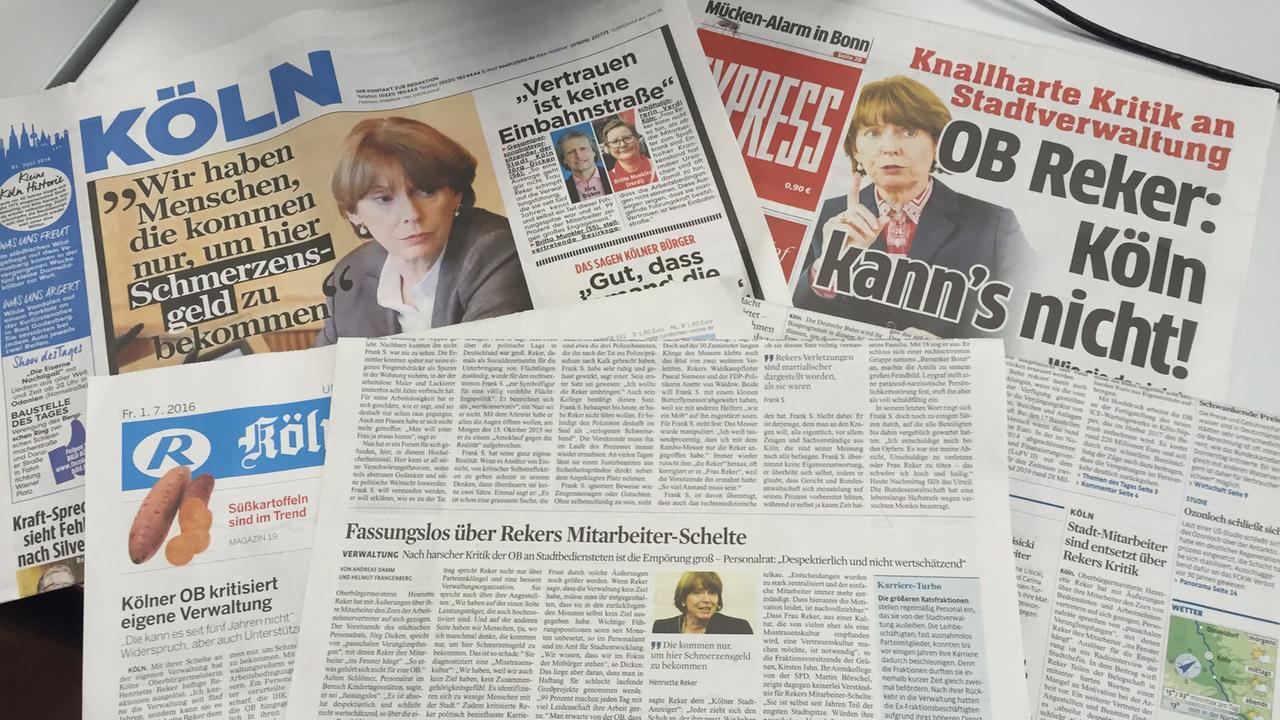 Mehrere Zeitung liegen übereinander und zeigen Artikel über Henriette Reker