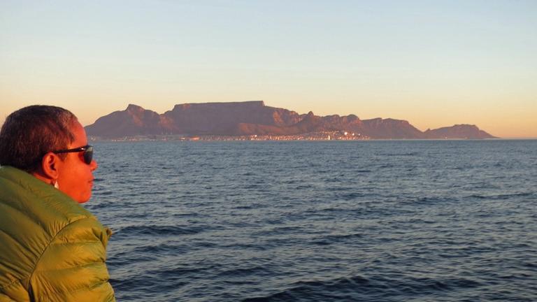 Die anglikanische Pfarrerin Rene August auf dem Schiff nach Robben Island, im Hintergrund Kapstadt mit dem Tafelberg.