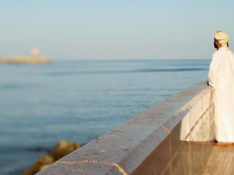 Ein Einheimischer blickt auf den Hafen von Maskat an der Muttrah Corniche.