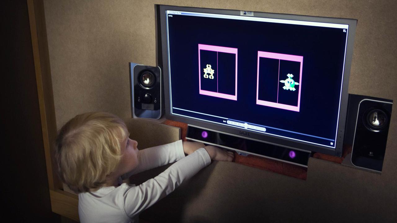 Ein Kind vor einem Computer im Babylab in Genf, in dem die sprachliche Entwicklung von Kindern untersucht wird.