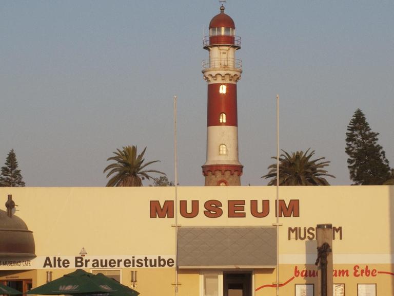 Der Leuchtturm von Swakopmund wurde 1902, während der Kolonialzeit, von deutschen Bauherren erbaut. Er ist noch heute in Betrieb. Davor das Swakopmund Museum in Namibia.