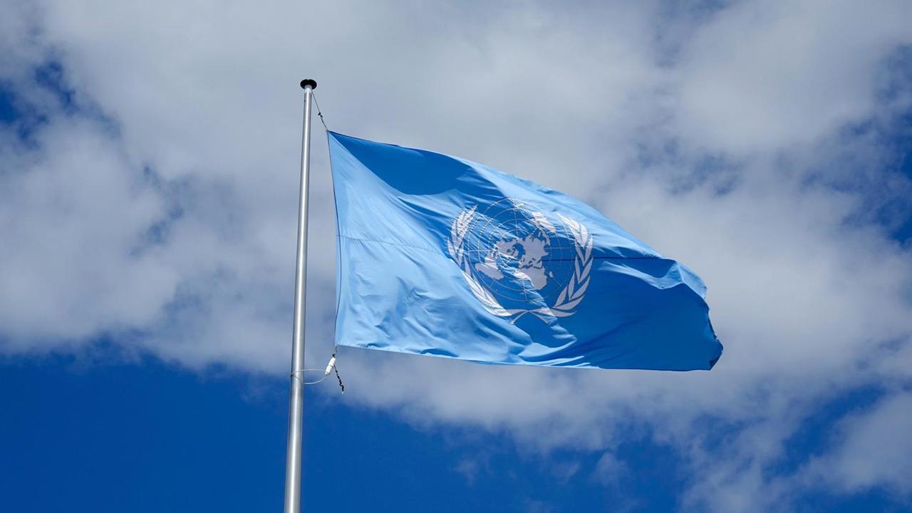 04.08.2017, Bonn, Nordrhein Westfalen, Vor einer weissen Wolke weht die Fahne der Vereinten Nationen in Bonn.