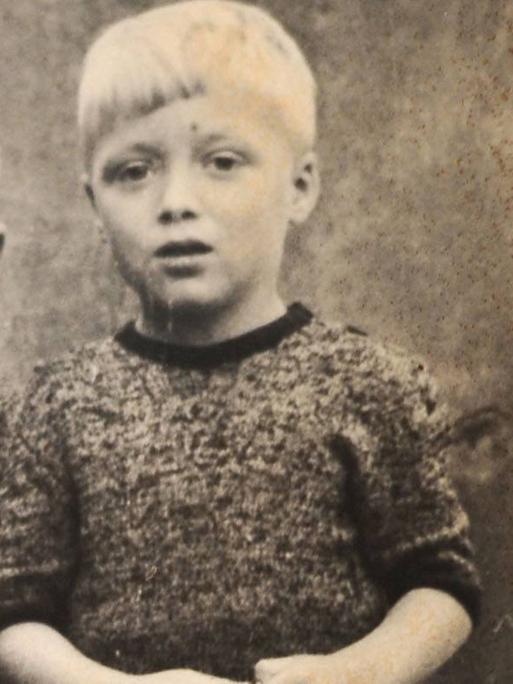 Eine alte Fotografie zweier Kinder. Eines hält einen Ball in der Hand.