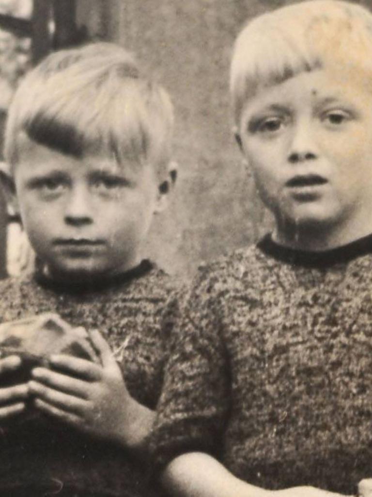 Eine alte Fotografie zweier Kinder. Eines hält einen Ball in der Hand.