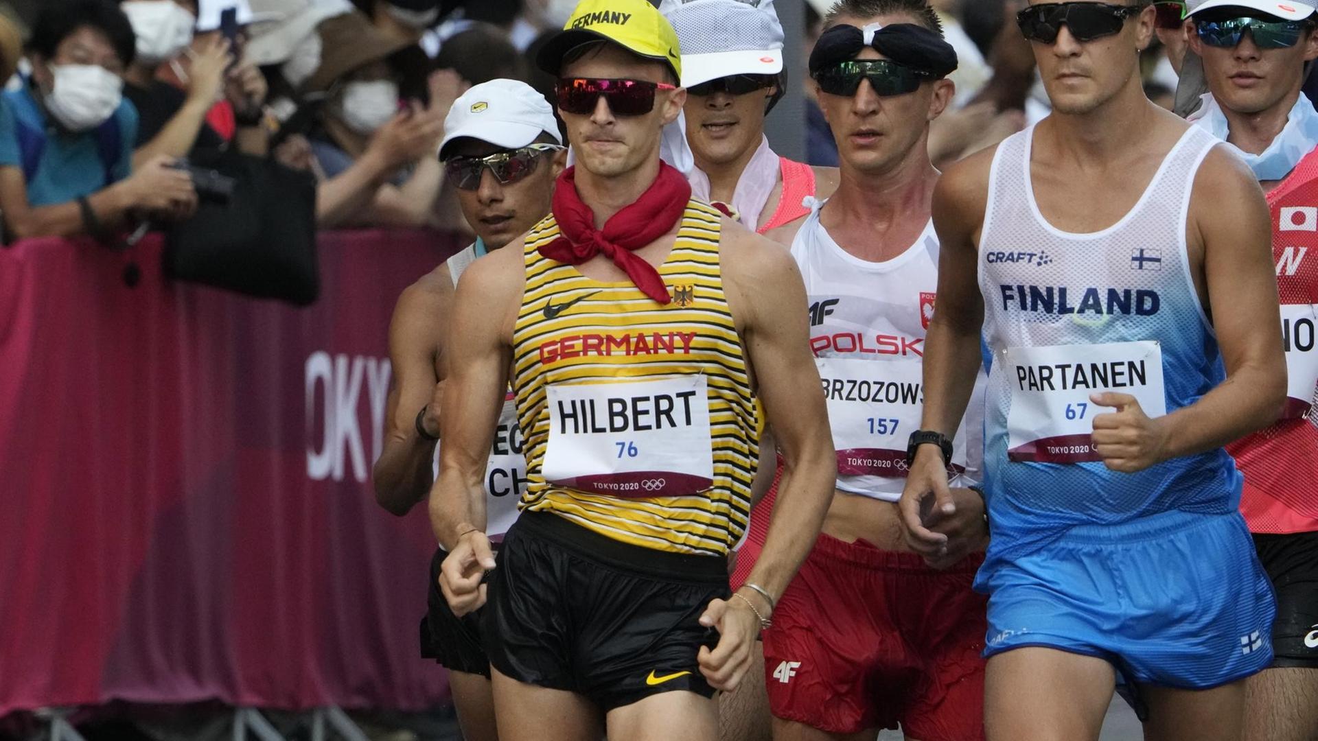 Der deutsche Geher Jonathan Hilbert in Aktion, um ihn herum sind weitere Athleten zu sehen.
