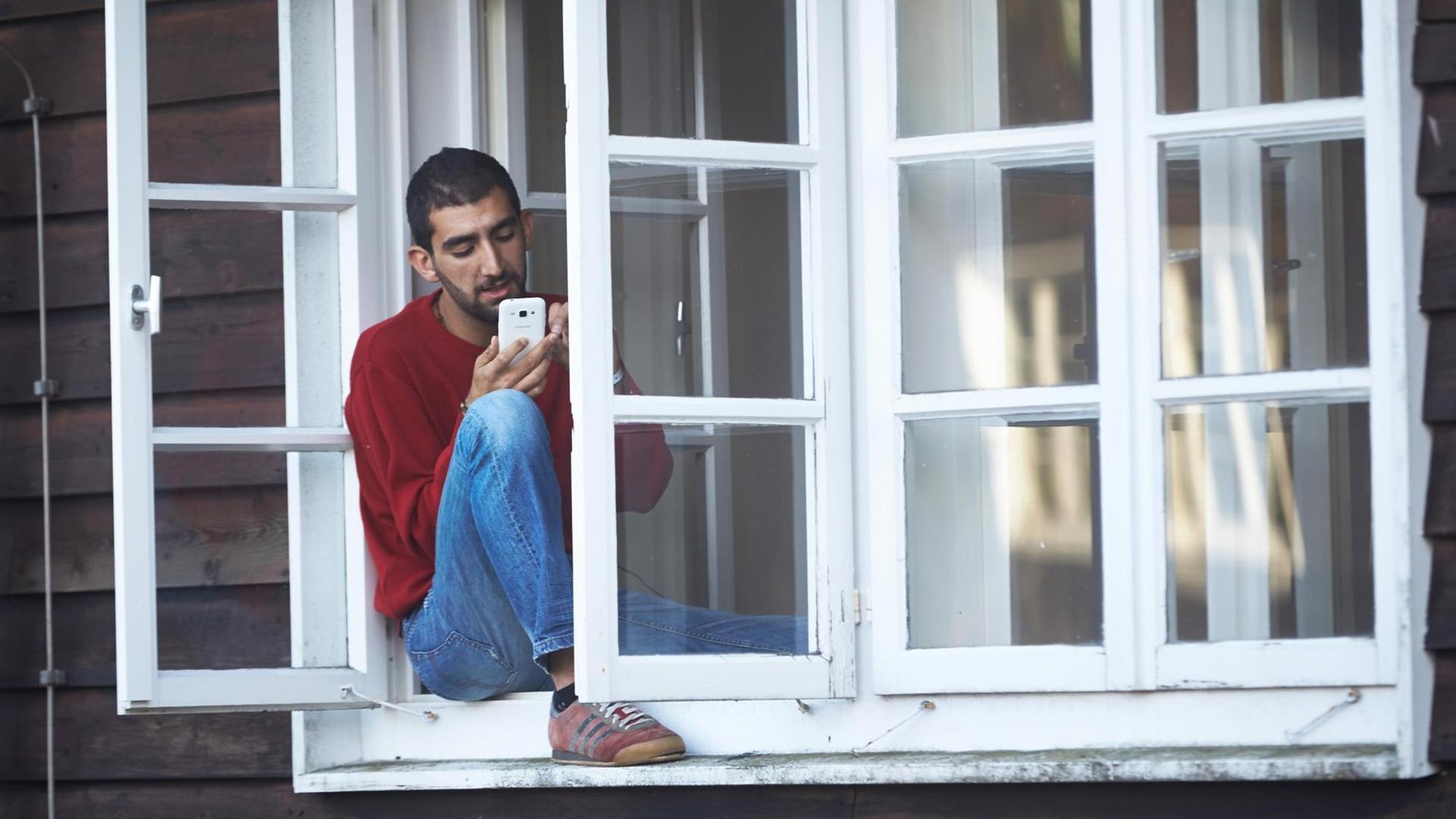 Elias aus Syrien telefoniert aus dem Lager Stegskopf auf dem ehemaligen Truppenübungsplatz bei Daaden (Rheinland-Pfalz) mit Verwandten in der Heimat.