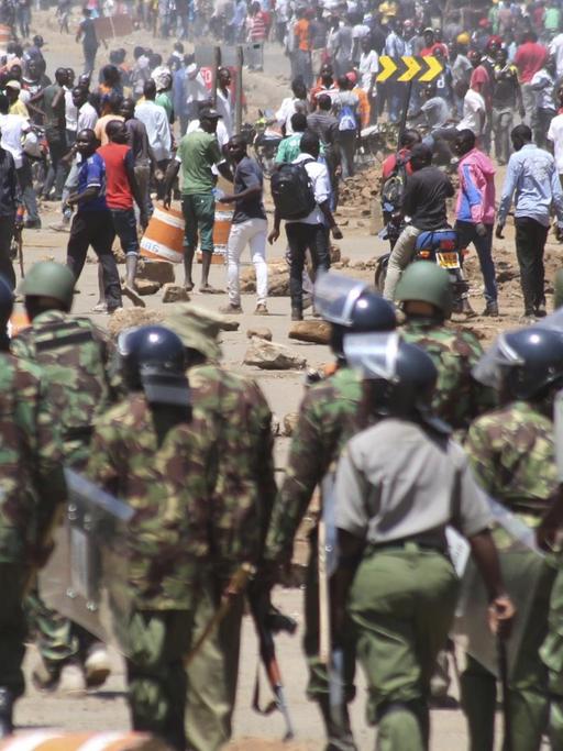 Polizisten einer Spezialeinheit treffen am 02.10.2017 in Kisumu (Kenia) auf eine Gruppe von Demonstranten. Im Streit um eine neue Präsidentschaftswahl in Kenia hat die Polizei teils Tränengas gegen Demonstranten eingesetzt. Hunderte Unterstützer der Opposition folgten am Montag dem Aufruf des Oppositionsführers Odinga und gingen in Kenias Hauptstadt Nairobi sowie in anderen Städten auf die Straße.