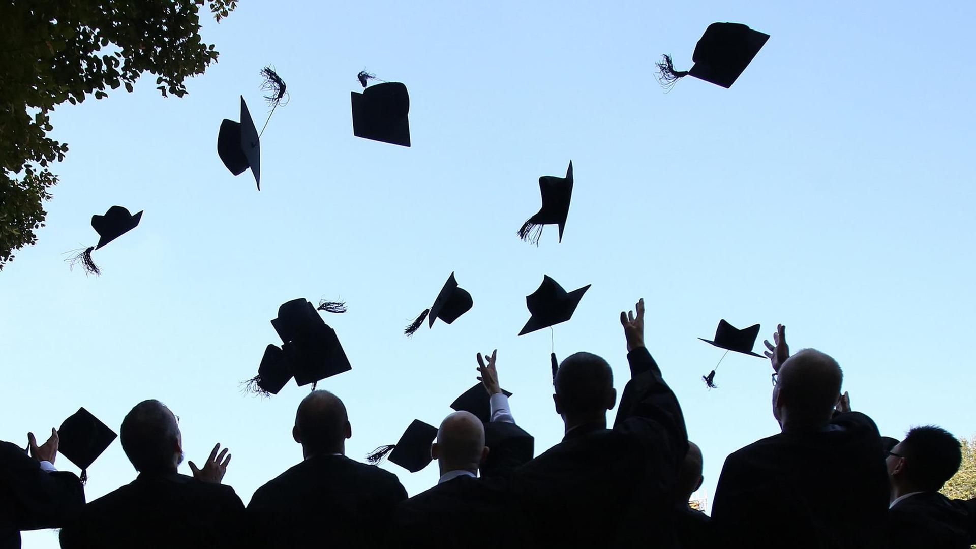 Absolventen der HHL Leipzig Graduate School of Management werfen ihre Doktorhüte.