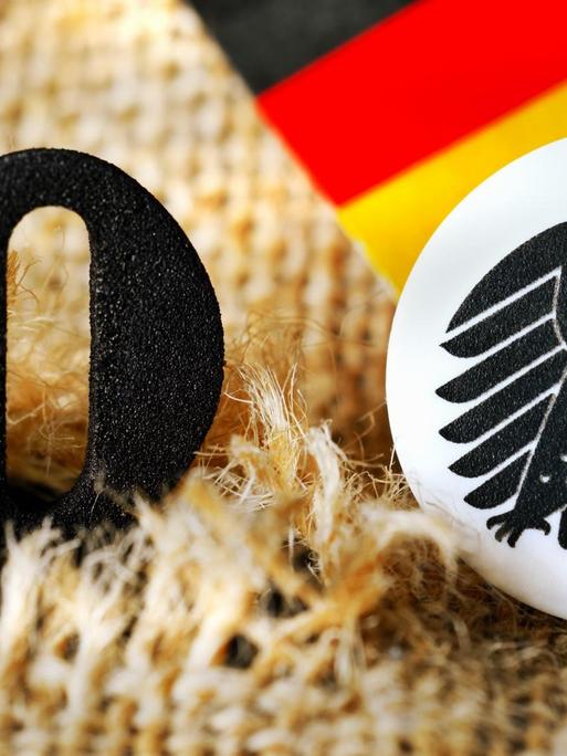 Die schwarze Null guckt aus einem aufgerissenen Geldsack heraus.