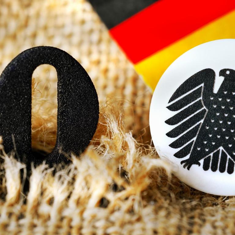 Die schwarze Null guckt aus einem aufgerissenen Geldsack heraus.