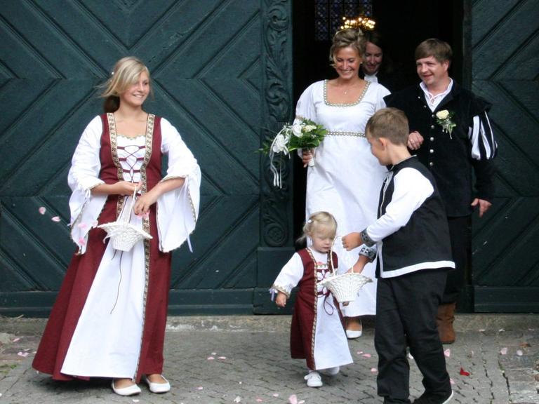 Das Brautpaar einer historischen Kaufmannshochzeit tritt aus der historischen Kirche in Anklam heraus. Seit 1283 ist Anklam mit Lübischem Recht Hansestadt.