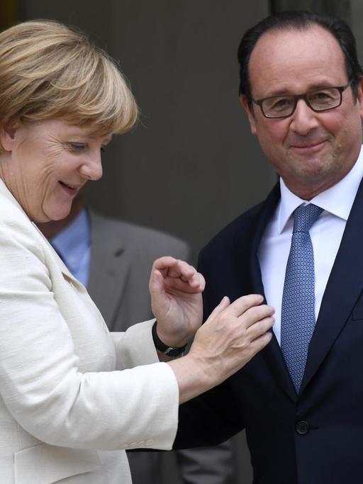 Bundeskanzlerin Merkel und Frankreichs Präsident Hollande stehen nach einem Treffen vor dem Elysee-Palast und wirken vertraut
