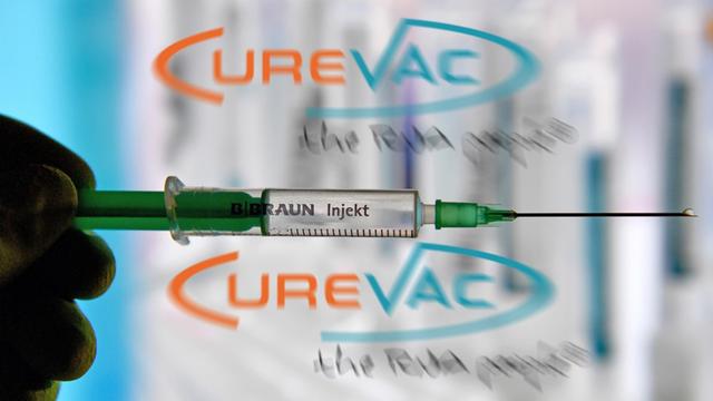 Das Foto zeigt eine Spritze vor dem Logo des Unternehmens CureVac.