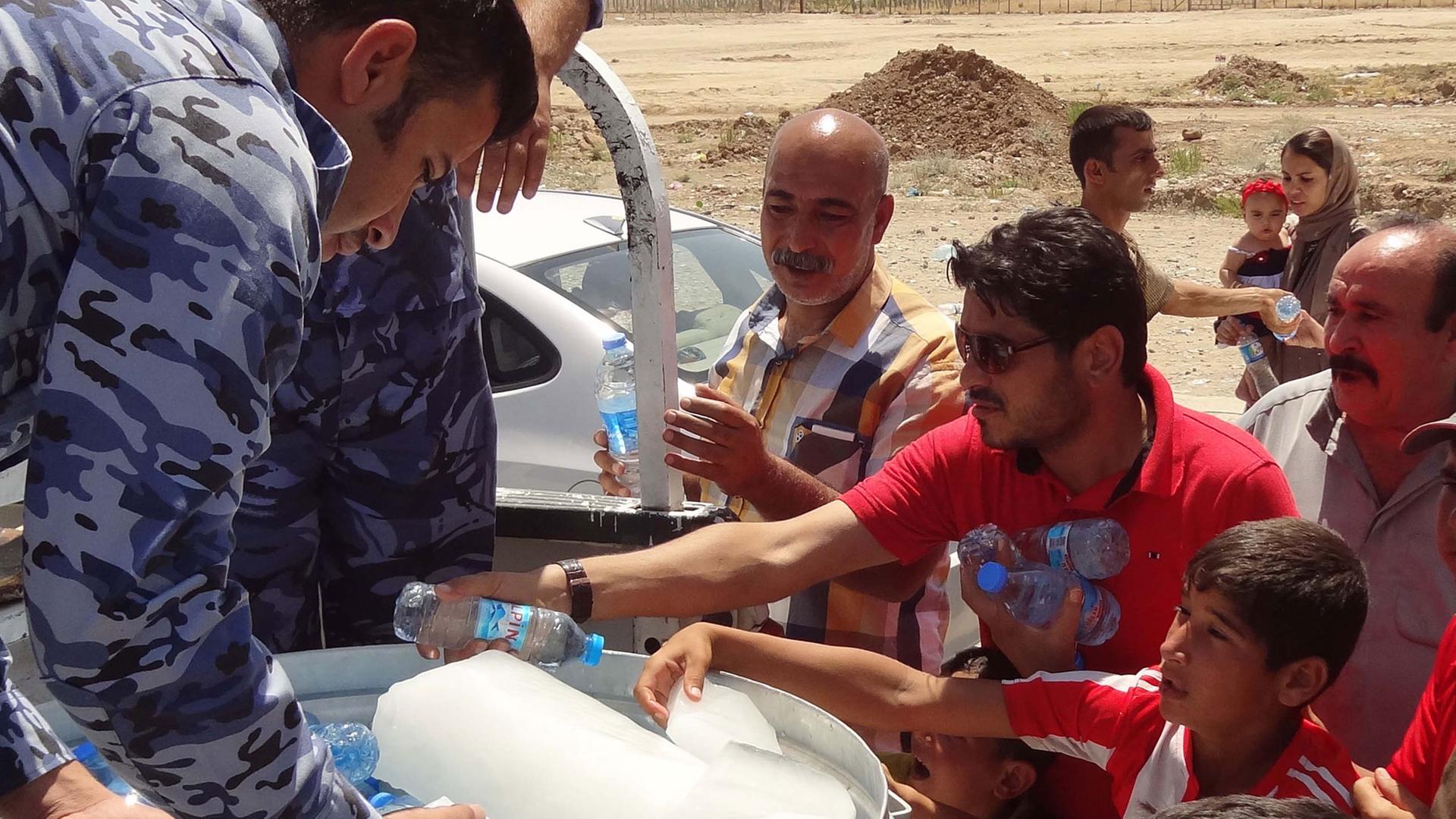 Irakische Militärs geben in Kirkuk Wasser an schiitische Kurden.