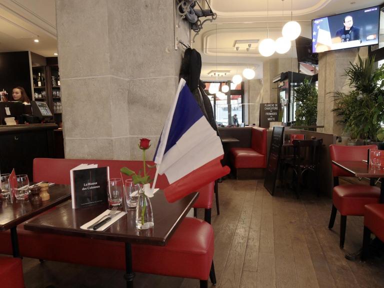Die französische Nationalflagge steht auf dem Tisch eines Pariser Restaurants.