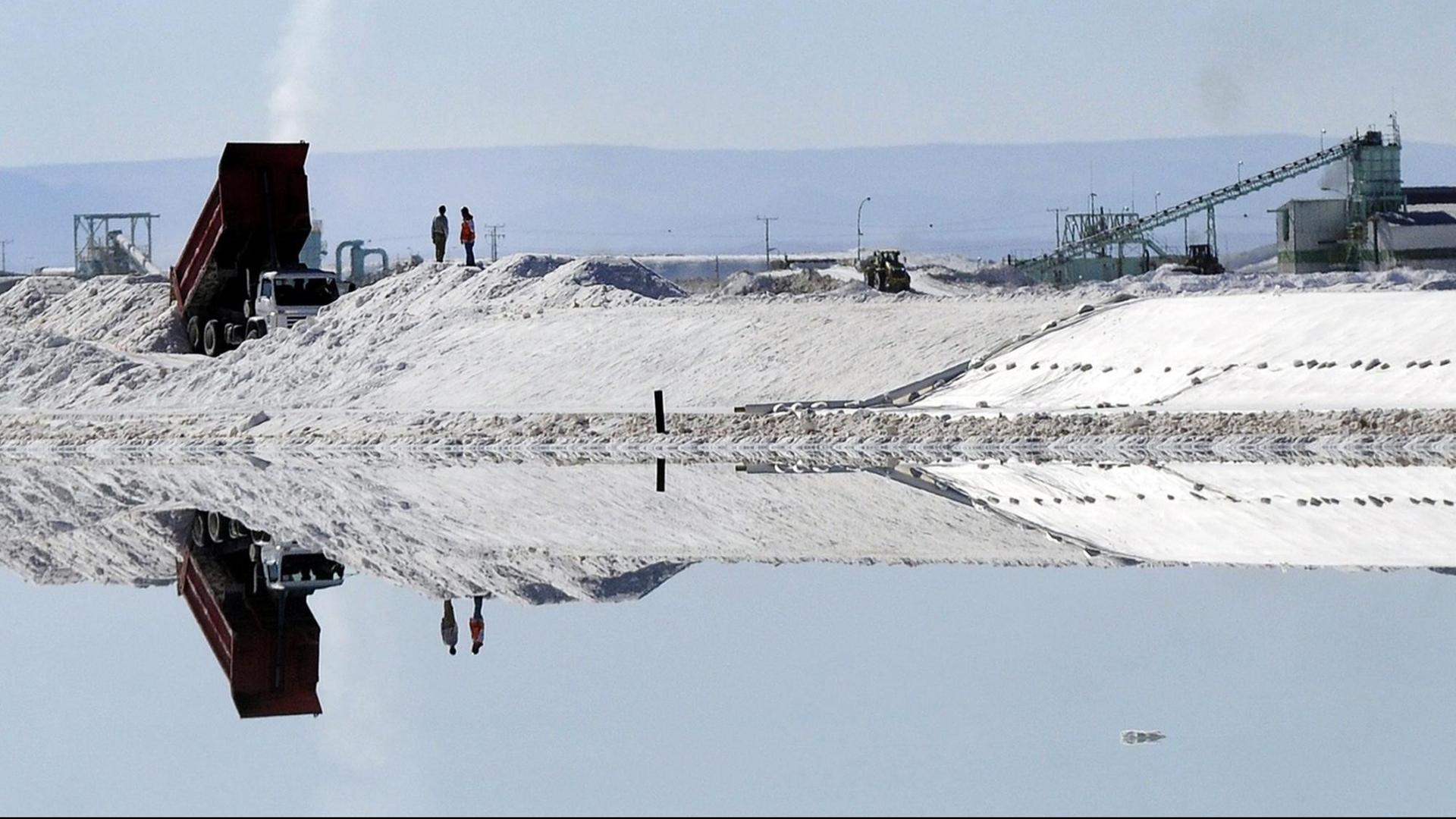 Arbeiter stehen am Verdunstungsbecken der SQM im Salzsee in der Atacamawüste im Norden Chiles