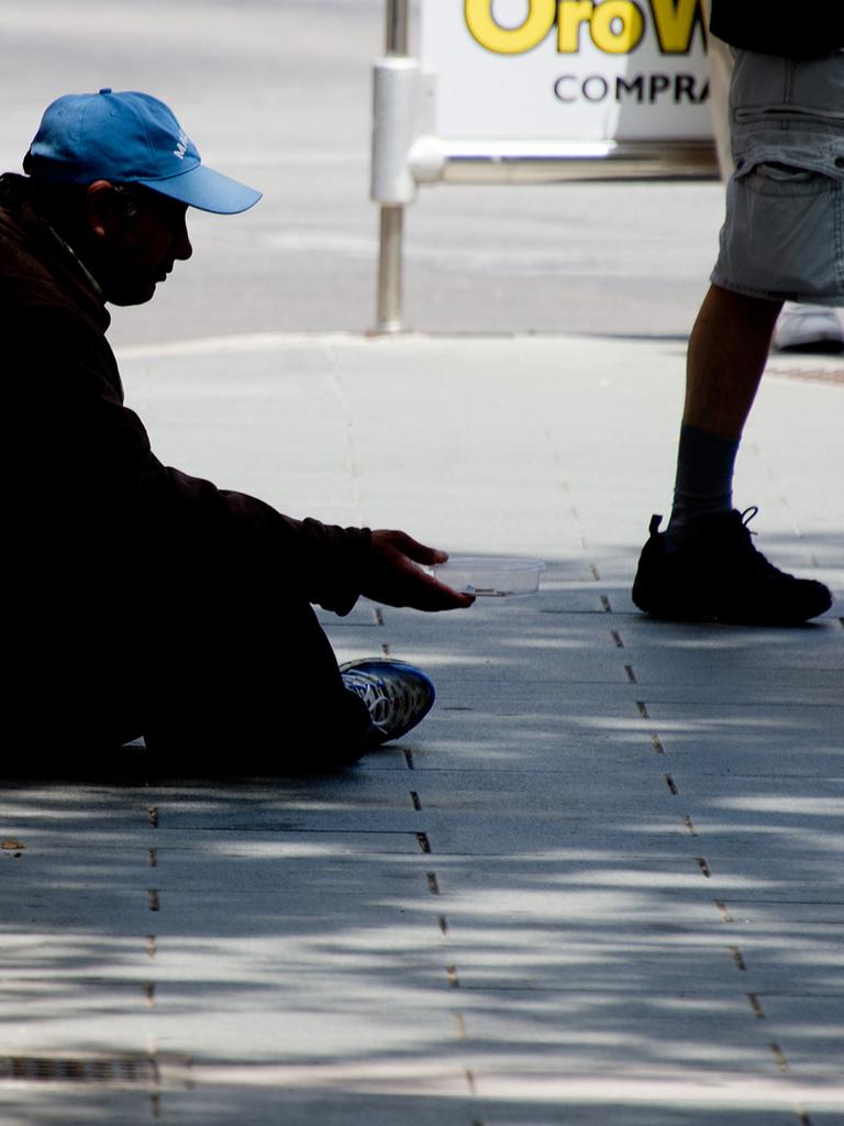 Ein Bettler sitzt in Palma de Mallorca auf dem Bürgersteig. 