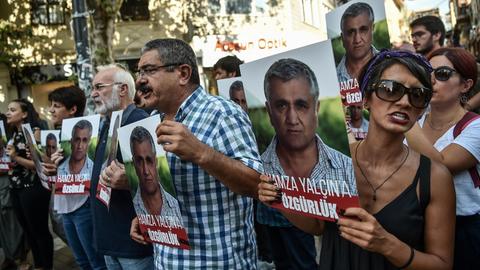 Demonstranten halten auf einer Kundgebung Porträts des schwedisch-türkischen Journalisten Hamza Yalçin in die Höhe, der am 3. August 2017 in Barcelona auf Veranlassung der Türkei verhaftet worden war.