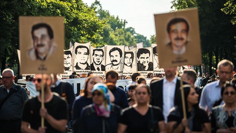 Das Foto zeigt die Teilnehmer einer Demonstration nach dem Urteil im NSU-Prozess. Sie halten Bilder der vom NSU Ermordeten hoch.
