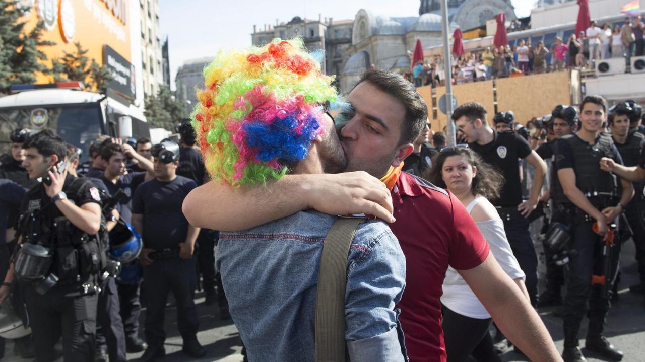 Zwei Männer küssen sich am 28. Juni 2015  vor einer Gruppe türkischer Polizisten bei der 13. Gay Pride Parade in Istanbul.  