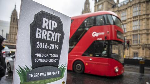 Ein Schild, auf dem steht, "RIP Brexit, es gab keine Alternative". Im Hintergrund ein roter, englischer Bus.