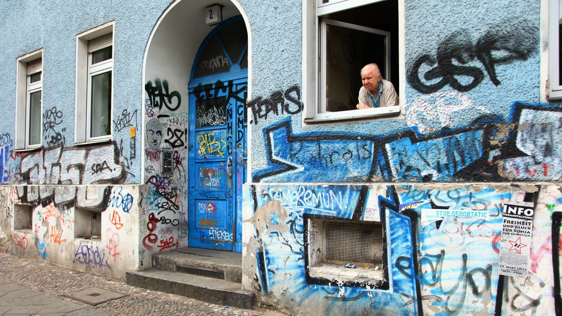 Eine alte Frau blickt aus dem Fenster ihrer Wohnung in Berlin im Bezirk Kreuzberg im Mai 2012.