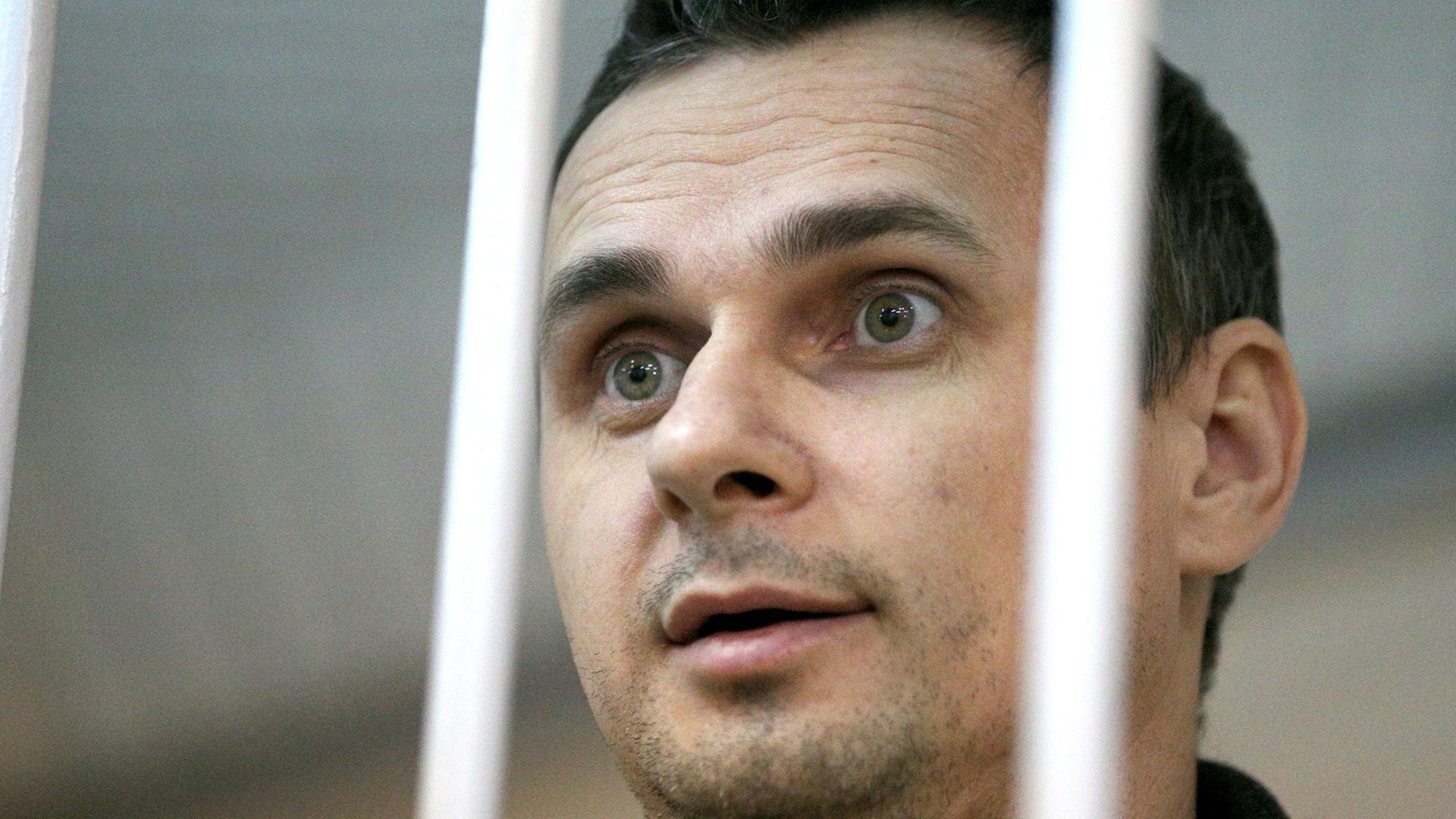 Der ukrainische Kinoregisseur Oleg Senzow wurde von einem russischen Gericht zu 20 Jahren Haft verurteilt; die Aufnahme zeigt ihn bei einer gerichtlichen Anhörung im Dezember 2014 in Moskau in einem Käfig.
