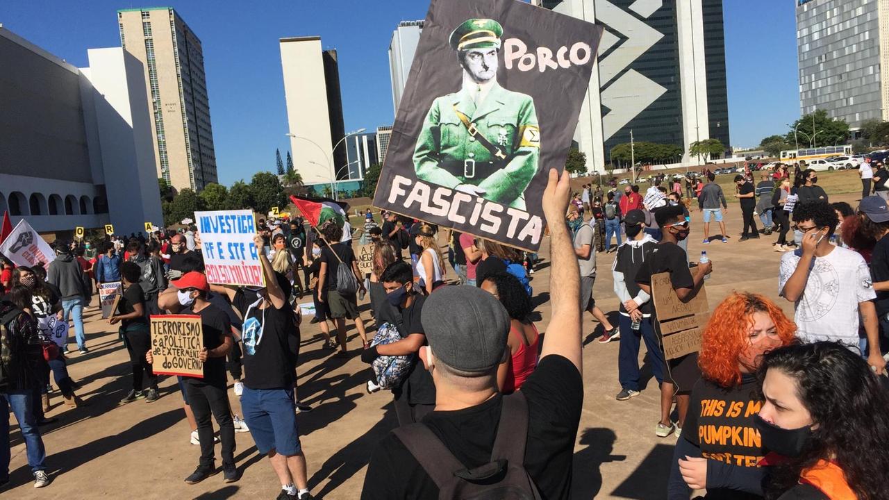 Menschen halten Plakate in die Luft und demonstrieren gegen Präsident Bolsonaro.