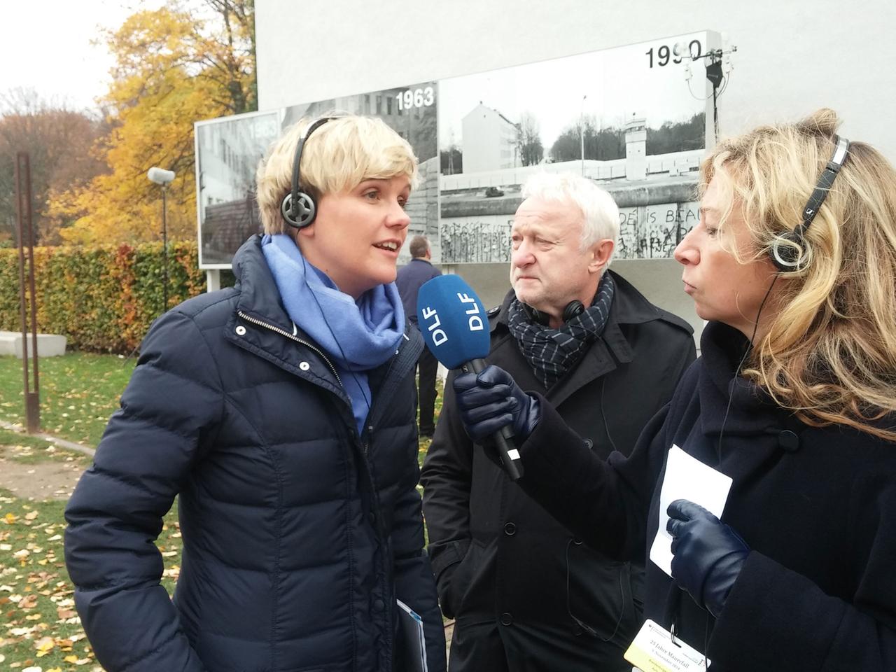 DLF-Redakteurin Bettina Klein im Interview mit Susanne Muhle, Mitkuratorin der Ausstellung "Stiftung Berliner Mauer". Im Hintergrund steht Grünen-Politiker Werner Schulz 