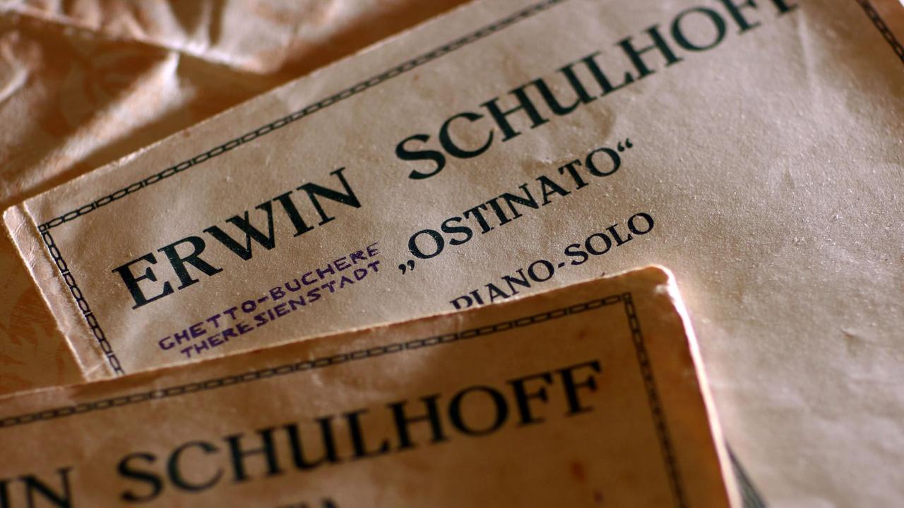 Verschiedene Notenbände auf einem Tisch, die den Komponistennamen Erwin Schulhoff tragen.