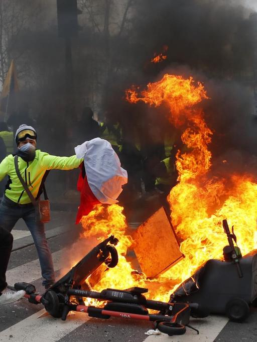 Am Pariser "Place de la Republique" setzen Demonstranten der sogenannte Gelbwesten Barrikaden in Brand.