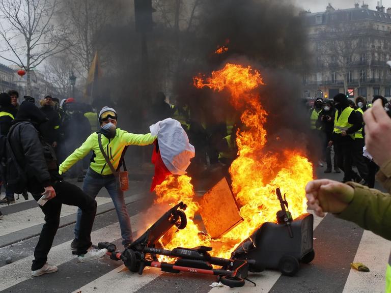 Am Pariser "Place de la Republique" setzen Demonstranten der sogenannte Gelbwesten Barrikaden in Brand.