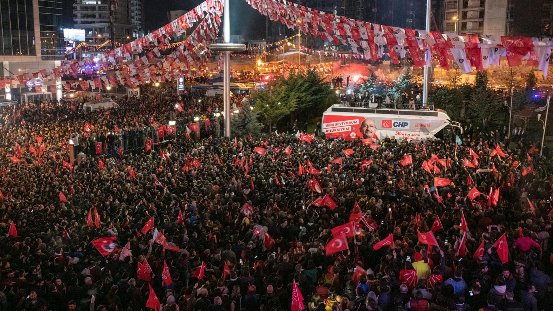 Eine Menschenmenge hat sich rund um einen Bus mit dem Bild des Kandidaten der türkischen Oppositionspartei CHP in Ankara versammelt und schwenkt türkische Flaggen.